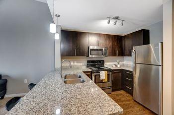 A kitchen with granite countertops and stainless steel appliances.